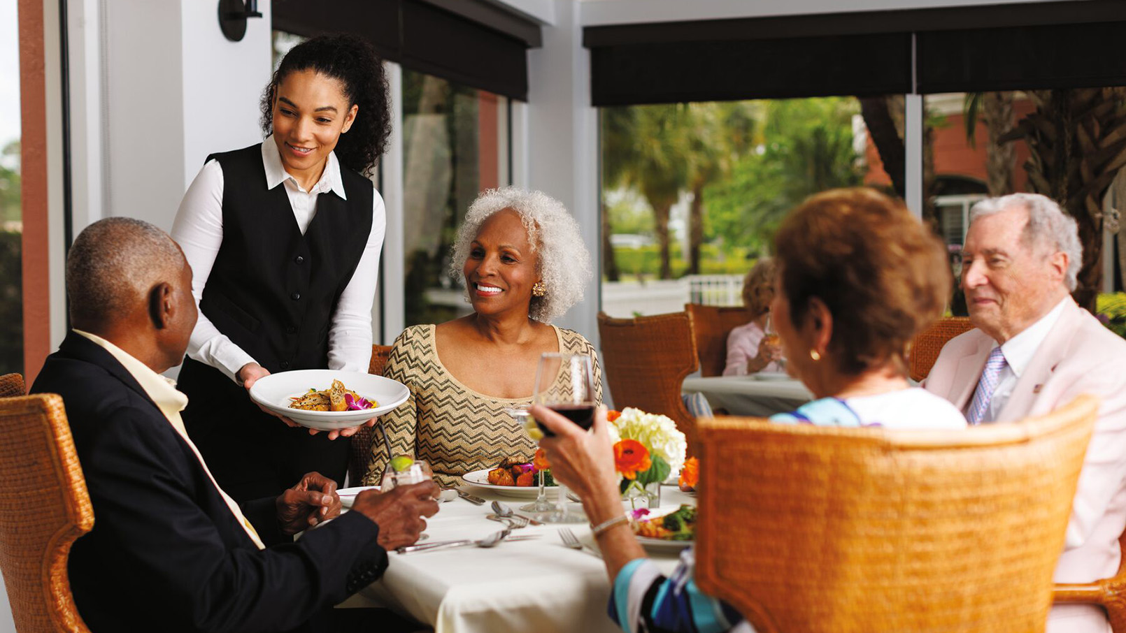 Residents enjoying a delicious meal together in the warm ambiance of our senior living community's dining area.