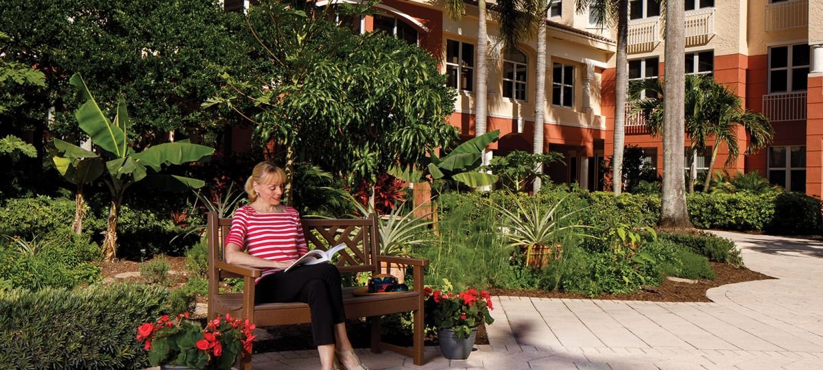 Erickson resident reads outside on a bench.