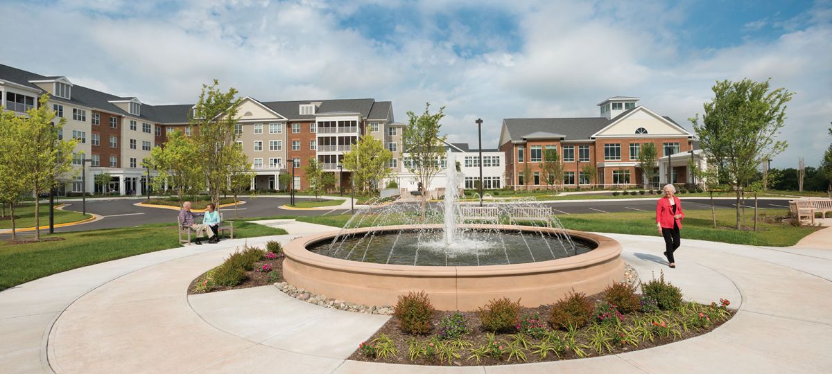 Erickson resident enjoying a walk next to an on-campus fountain.