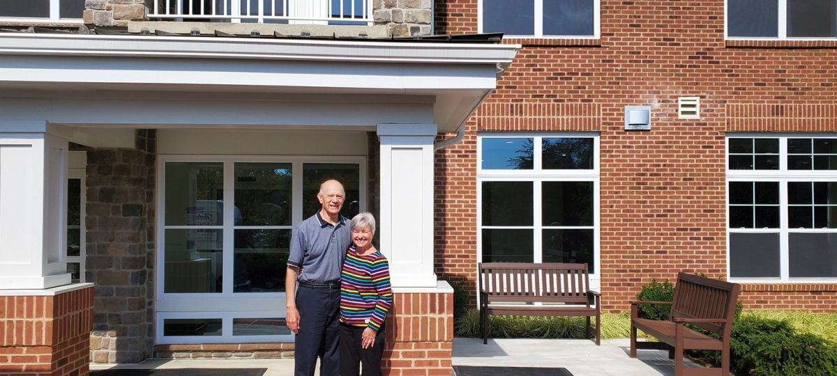 Lantern Hill couple standing in front of an apartment building.