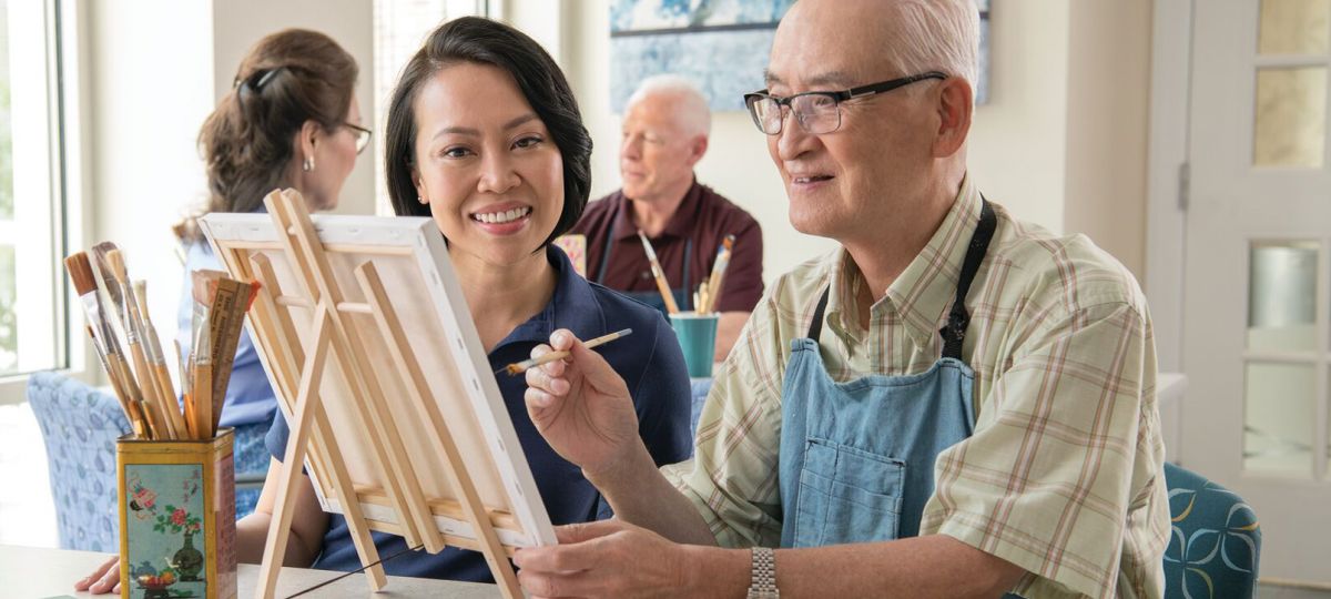 Smiling resident working on a painting
