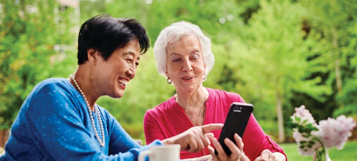 Two women look at a smart phone