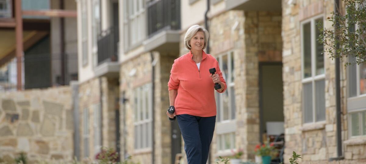 Senior woman walks with weights